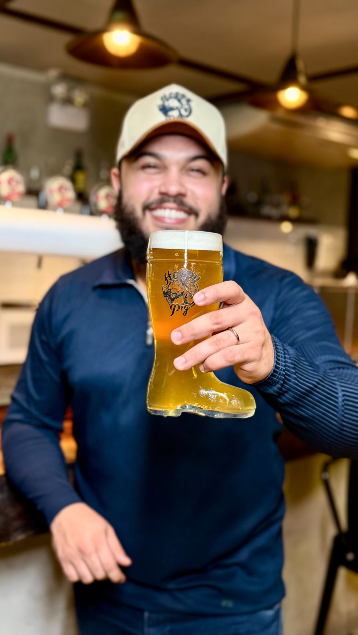 Cliente brindando com o chopp na bota do Hoppy Pig